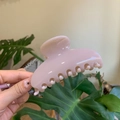 Detail of a pink glossy hair claw clip held against a green plant background - 10cm Yuanbao Claw / Light Nude Pink