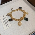 Detalle de pulsera dorada de temática oceánica con colgantes de conchas y estrellas de mar - Pulsera de Oro con Estrella de Mar y Conchas