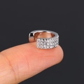 Macro detail of silver zircon clip-on earring on finger showing sparkling multi-row stones - 6# (White Gold)