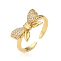 Anello regolabile a fiocco dorato con micro-pavé di zirconi su uno sfondo bianco puro - Stile CE00841YH / Oro