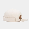 Close-up of beige PARIS embroidery on the folded brim of a canvas docker hat - Beige