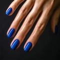 Glossy deep blue solid color press-on nails shown on hand with high shine finish - Dark Blue