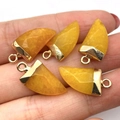 Handheld group of five yellow moon-shaped stone pendants with gold metal caps - 10x20mm / Topaz