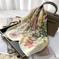 Eleganter Seidenschal mit Blumenmuster auf Gelb neben einer braunen Handtasche - Gelb
