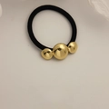 Minimalist black elastic hair tie featuring three polished gold metallic spherical beads - Glossy Three Round Gold