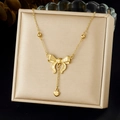 Dettaglio di collana con fiocco dorato e cuore esposta su una scatola per gioielli - Stile Pendente a Cuore con Fiocco Lucido (N3942)