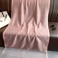 Elegant pink silk shawl with sheer paneling draped on a leather sofa with lifestyle accessories - Snow Bud