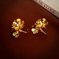 Detail of vintage gold flower earrings with layered petals on a retro book background - Gold Flower Studs / Gold (Silver Earring Post)