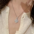 Silver clover necklace with embedded gemstones worn by a model for a chic, trendy look - Necklace - Silver