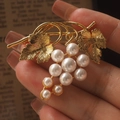 Designer golden grape brooch with white pearls and detailed leaf textures on vintage paper - Artificial Pearl Style