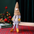 Detailed view of handmade knitted Christmas gnome doll with long legs on festive background - Brown Female Style