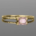 Detail of golden textured ring featuring a rectangular pink gemstone on a mirrored surface - US 5 / Pink