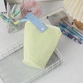 Close-up of a large capacity two-tone pencil case with a portable handle on a desk tray - Yellow
