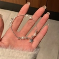 Elegante bracciale in argento con perle bianche e ciondolo a stella sul polso di una donna - Argento (Stella Perla)