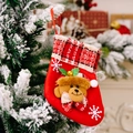 Mini roter Weihnachtsstrumpf mit Plüschbär und Glocken an schneebedecktem Zweig dekoriert - Bär