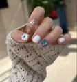 Close-up of blue cat-eye press-on nails with daisy floral art and silver mirror finish - Sea Salt Daisy (S165) / XS