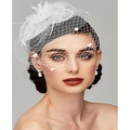 Dettaglio di un fascinator da sposa bianco con piume, velo a rete e delicati decori floreali - Bianco