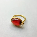 Detail of 18K gold-plated ring featuring an oval red gemstone and clear zircon accent - US 6 / Red
