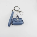 Detail view of a blue PU leather mini bag keychain with silver hardware - Sky Blue