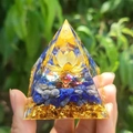 Pyramide en résine avec pierres bleues et lotus doré tenue dans la main - Style 28