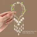 Detail of lily of the valley hair clip with golden tassels and green leaf accents - Vine Lily of the Valley Tassel