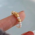 Elegant gold mythical beast ring with white pearls on a hand, minimalist luxury style - Pixiu Fortune Pearl Beaded Ring