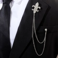 Détail d'une broche lys en argent avec chaînes et strass sur le revers d'un costume noir - Fleur-de-lis Lys Argent (TL24072)