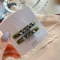 Detail of green heart rhinestone hair clips with pearls on a decorative white card - Heart Style Green Pair