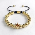 Close-up of golden beaded bracelet with crown charm and adjustable black braided cord - Round Beads Braided Crown Gold
