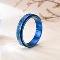 Detailed macro view of the blue matte frosted finish spinner ring on a soft background - US 5 / Blue Sandblasted Spinner Ring