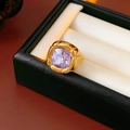 Close-up of vintage golden ring with faceted purple gemstone in black jewelry box - Gold-Purple