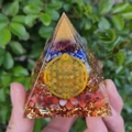 Pyramide en cristal et résine avec feuille d'or et motif géométrique tenue en main - Style 47