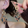Nahaufnahme von geometrischen Leoparden-Ohrhängern in Gold-Optik an einem Model - 29# Silberner Ohrstecker - Braun - Geometrischer Rhombus