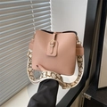 Bolso cubo rosa de cuero con correa ancha estampada mostrado en un ambiente interior - Rosa