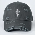 Detail van donkergrijze distressed katoenen baseballpet met witte roos en LOVE-borduur - Eén maat / Grijs