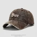 Dettaglio cappellino bimbo in cotone lavato con ricamo But e toppa effetto invecchiato - 54cm / caffè