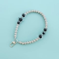 Detail view of silver metal keychain with pearls, black star pendant and rhinestones - Black Star