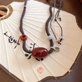 Dettaglio della collana con perle di corniola, giadeite e ciondolo Ruyi in argento - Marrone-Rosso