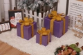 Three purple Christmas gift boxes with golden glitter ribbons in festive holiday scene - Laser Purple Christmas Gift Box