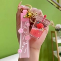 Porte-clés fraise rose en acrylique avec liquide flottant, paillettes et grelot doré - Tasse de thé au lait avec bracelet en silicone