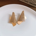Nahaufnahme goldener unregelmäßiger geometrischer Ohrstecker auf weißem Teller - Gold / Gold