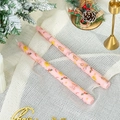 Detail of two pink Christmas taper candles with gingerbread and tree prints on white mesh - Christmas Berry (Pink)