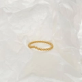 Macro detail of a V-shaped golden beaded ring on a minimalist white textured paper - Small Beaded V-Shape