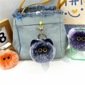 Dettaglio di portachiavi a forma di gatto di peluche grigio e arancione su borsa in denim - confezione in singolo sacchetto opp / Blu navy