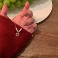 Golden Fu character pendant necklace with white pearls on a red knit sweater - Fu Character Pearl Style