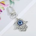 Silver Hamsa Hand keychain with blue Evil Eye bead and sparkling rhinestone accents - Silver Hollow Flower Hand 13