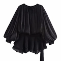 Detail of black satin dress showing elegant lantern sleeves and tiered ruffle hemline - Black Dress