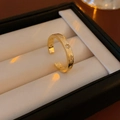 Detail of gold star ring with brushed texture on elegant black and white jewelry box - Gold