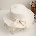 Détail d'un chapeau de paille blanc avec ruban beige et boucle en strass brillant - Blanc