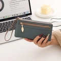 Close-up of litchi grain long wallet in grey-blue with golden leaf pendant detail - Green